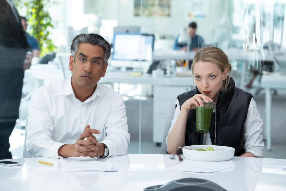 a man and a woman sit in an office