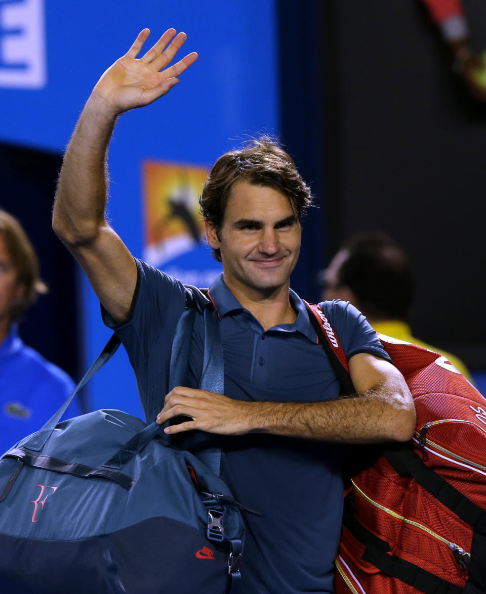 Roger Federer of Switzerland waves after defeating Andy Murray of Britain in their quarterfinal at the Australian Open tennis championship in Melbourne, Australia, Wednesday, Jan. 22, 2014. (AP Photo/Aaron Favila)