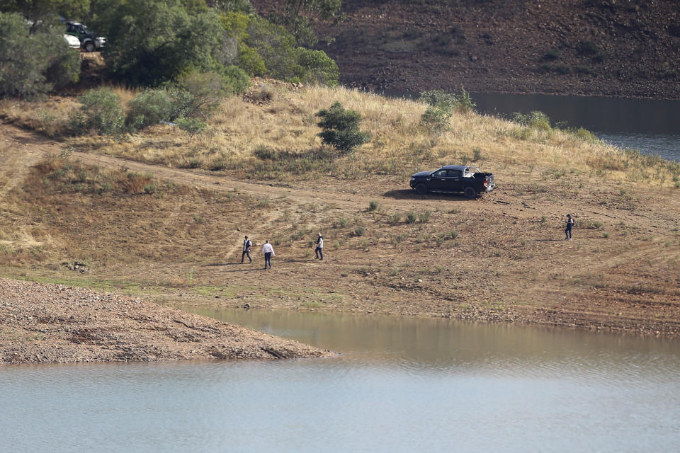 A police search team walk on the shore of the Arade dam near Silves, Portugal, Wednesday May 24, 2023. Portuguese police aided by German and British officers have resumed their search for Madeleine McCann, the British child who disappeared in the country's southern Algarve region 16 years ago. Some 30 officers could be seen in the area by the Arade dam, about 50 kilometers (30 miles) from Praia da Luz, where the 3-year-old was last seen alive in 2007. (AP Photo/Joao Matos)