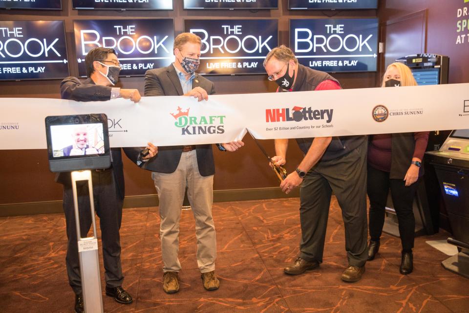 SEABROOK, NH - OCTOBER 23:  (L-R) Andre Carrier via ipad, Greg Lee,  Governor Chris Sununu, Charlie McIntyre, executive director of the New Hampshire Lottery and Jen Aguiar, vice president of compliance for DraftKings during the DraftKings Sportsbook at The Brook ribbon cutting on October 23, 2020 in Seabrook, New Hampshire.  (Photo by Scott Eisen/Getty Images for DraftKings)