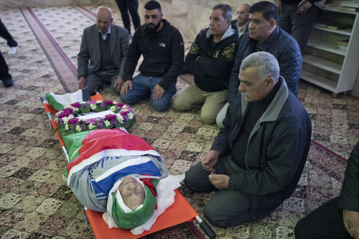 Mourners pray by the body of 78-year-old Omar Assad, a Palestinian who has U.S. citizenship, during his funeral at a mosque, in the West Bank village of Jiljiliya, north of Ramallah, Jan. 13, 2022. (AP Photo/Nasser Nasser)