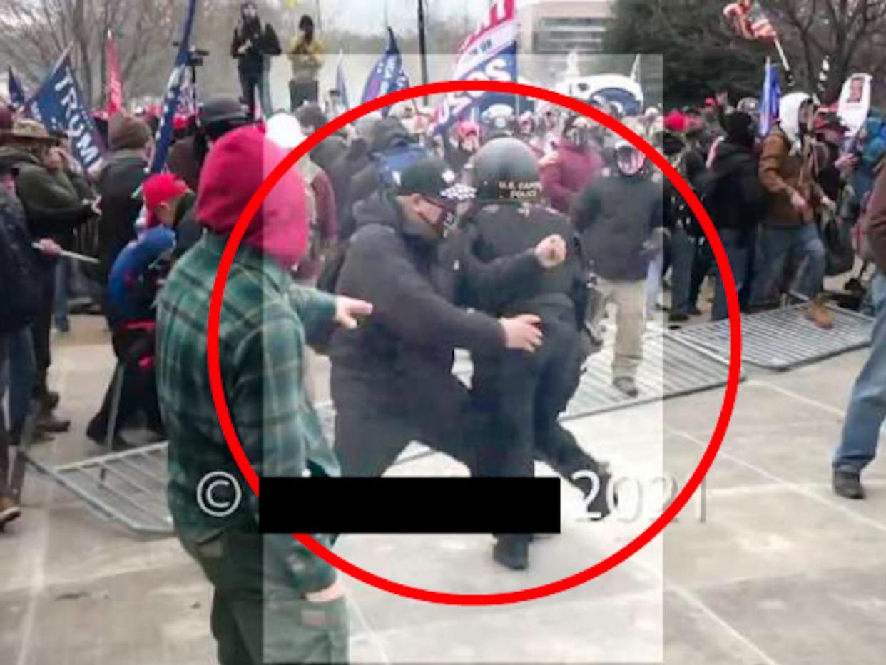 A screenshot of a video showing Woods assaulting a police officer