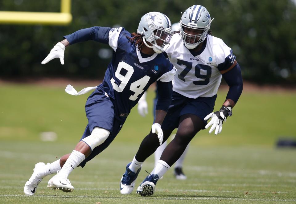 Randy Gregory (94) goes through drills against offensive tackle Ty Nsekhe.