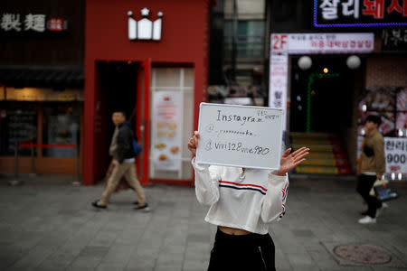 Japanese Yuuka Hasumi, 17, who wants to become a K-pop star, promotes her Instagram account during her street performance in Hongdae area of Seoul, South Korea, March 21, 2019. REUTERS/Kim Hong-Ji