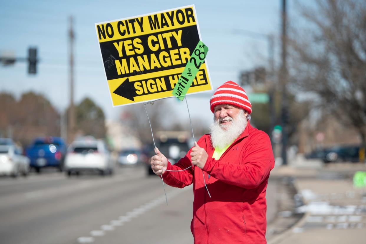 Dave DeCenzo holds a sign at an anti-mayor petition gathering site on Wednesday, Feb. 24, 2023