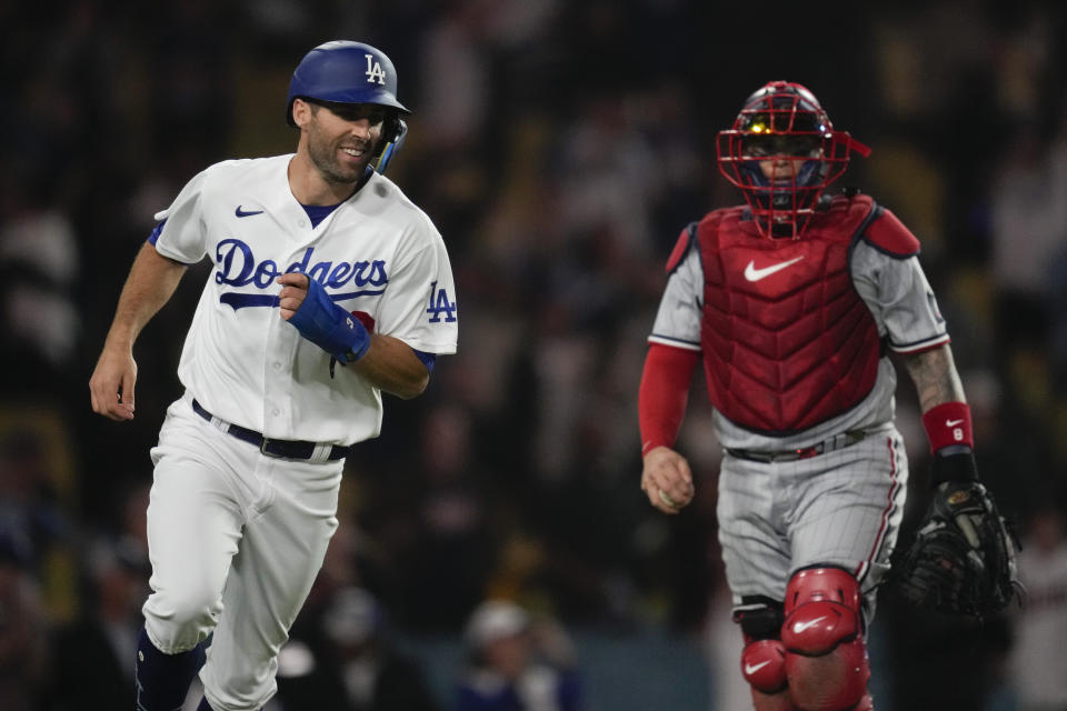 Los Angeles Dodgers' Chris Taylor, left, reacts after scoring during the twelfth inning of a baseball game against the Minnesota Twins in Los Angeles, Monday, May 15, 2023. The Dodgers won 9-8 in the 12th inning. (AP Photo/Ashley Landis)
