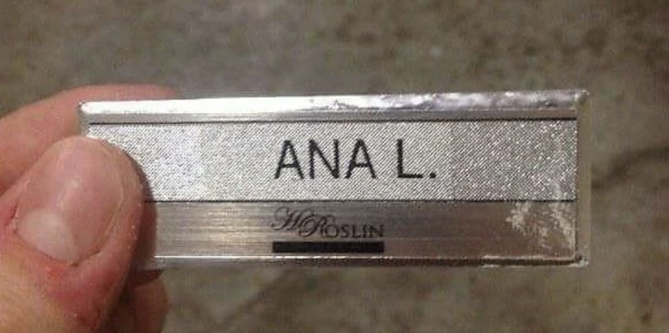 A hand holds a name badge that reads "ANA L." At the bottom, it says "H.Q. ROSLIN."