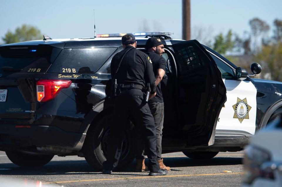 A man is escorted to a sheriff’s vehicle after a shooting at the Sacramento Sikh Society Temple, it is unknown if he was involved, on Sunday, March 26, 2023, in Sacramento. The shooting occurred during the Sacramento Sikh Society’s first Nagar Kirtan Parade.