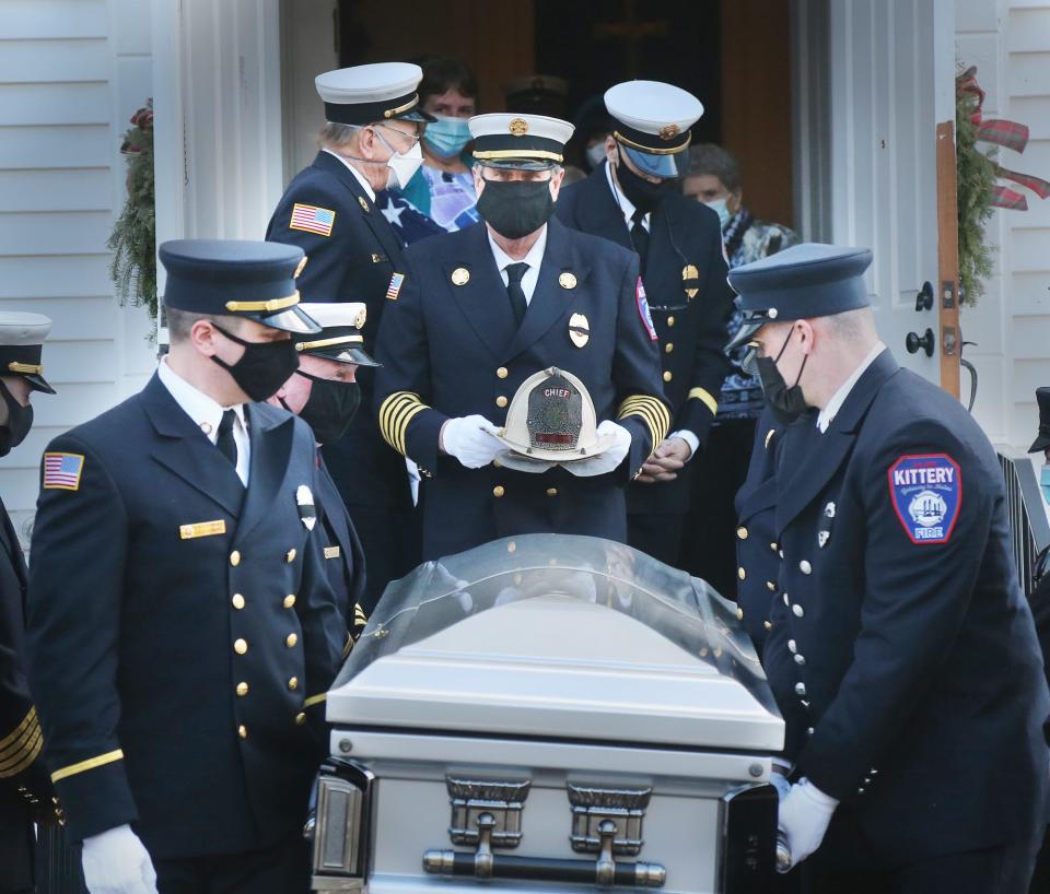 Kittery Fire Chief David W. O'Brien carries the helmet of retired chief, George D. Varney Jr. at the First Congregational Church United Church of Christ in Eliot Tuesday, Jan. 18, 2022, during Varney's funeral.