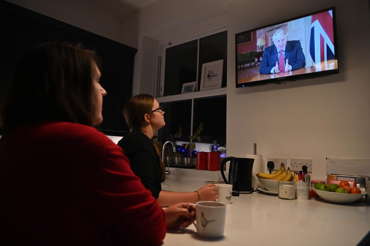 Members of a family watch as Britain's Prime Minister Boris Johnson addresses the nation about the latest updates on the novel coronavirus COVID-19 restrictions, on their television in their home in Liverpool on September 22, 2020. - Britain on Tuesday tightened restrictions to stem a surge of coronavirus cases, ordering pubs to close early and advising people go back to working from home to prevent a second national lockdown. (Photo by Paul ELLIS / AFP) (Photo by PAUL ELLIS/AFP via Getty Images)