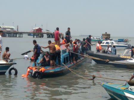 People stand atop a boat near Tarakan, North Kalimantan, Indonesia, July 25, 2017 in this picture obtained from social media. Yanto/Honda Marine Tarakan via REUTERS