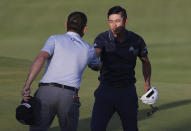 United States' Collin Morikawa, right bumps fists with South Africa's Louis Oosthuizen after they completed their third round on the 18th green at the during the third round of the British Open Golf Championship at Royal St George's golf course Sandwich, England, Saturday, July 17, 2021. (AP Photo/Ian Walton)