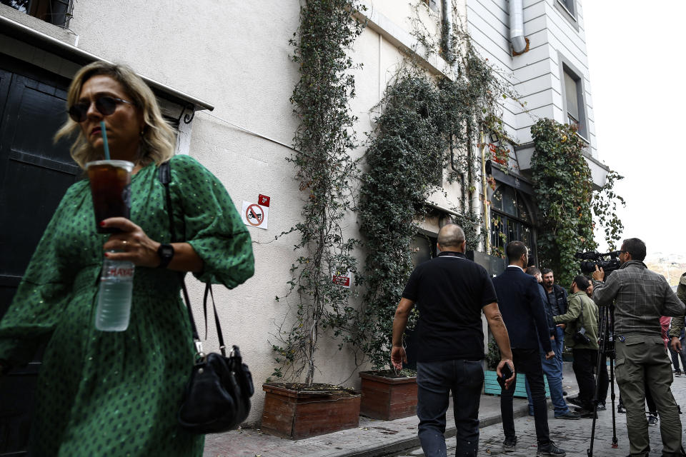 Media members work as people walk past the house of deceased British army officer James Le Mesurier who helped found the "White Helmets" volunteer organization in Syria, in Istanbul, Wednesday, Nov. 13, 2019. The Istanbul chief prosecutor's office said Tuesday an autopsy and other procedures were underway at Istanbul's Forensic Medicine Institute to determine "the exact cause" of Le Mesurier's death.(AP Photo/Emrah Gurel)