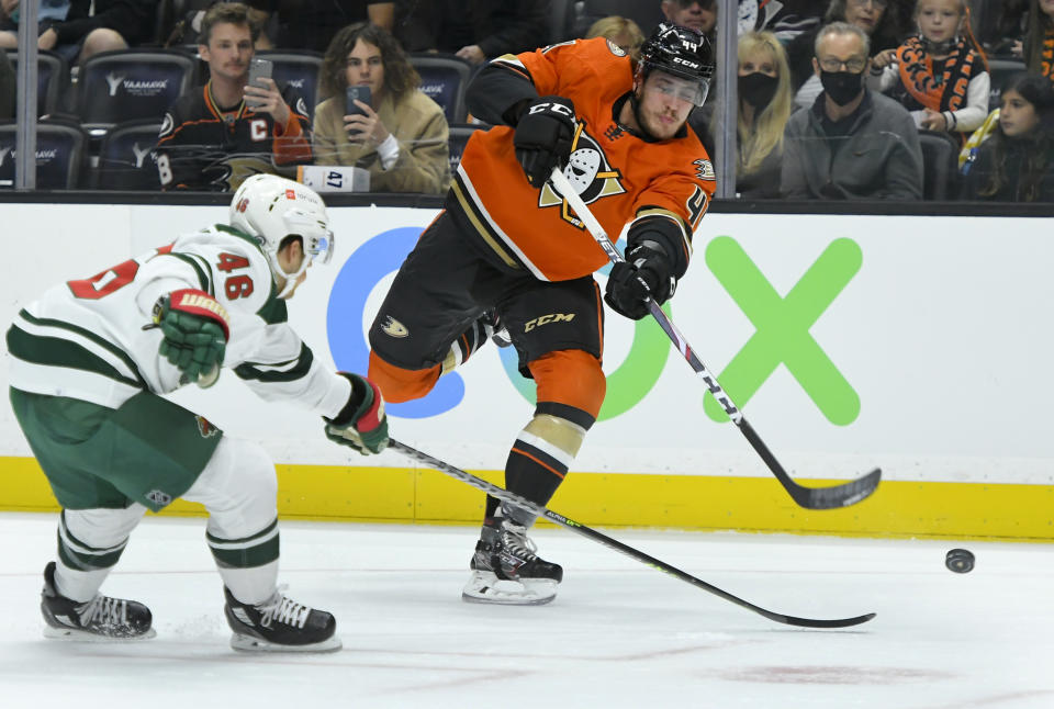 Anaheim Ducks left wing Max Comtois (44) shoots past Minnesota Wild defenseman Jared Spurgeon (46) during the second period of an NHL hockey game Friday, Oct. 15, 2021, in Anaheim, Calif. (AP Photo/John McCoy)