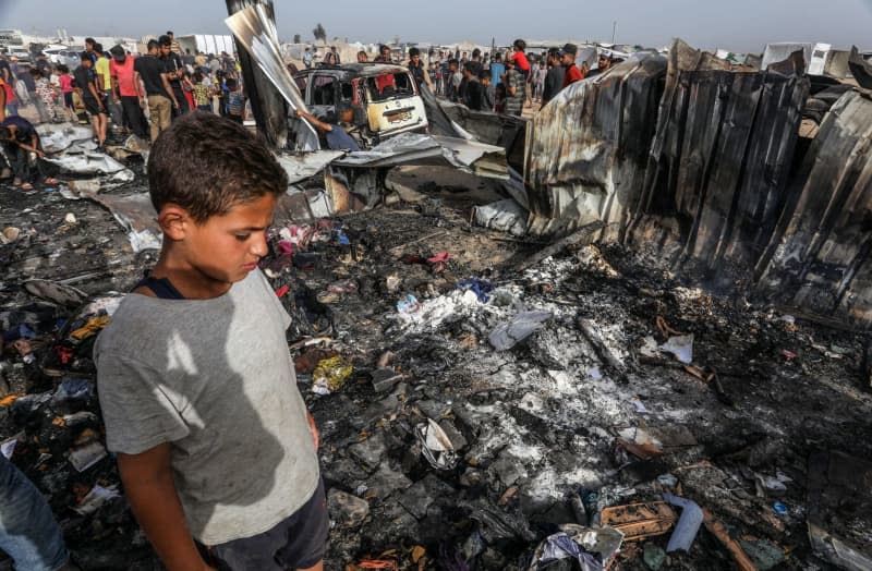 Palestinians inspect their destroyed tents after an Israeli airstrike, which left numerous dead and injured, in the Al-Mawasi area, which was bombarded with a number of rockets targeting the tents of displaced people west of the city of Rafah in southern Gaza Strip.  Abed Rahim Khatib/dpa