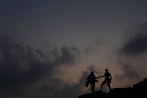 File photo shows a couple walking on rocks near a beach in Hong Hong. "Hong Kong is too crowded and lacks the privacy people need to have sex," said sex expert Emil Ng