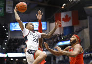 UConn's Jordan Hawkins, left, winds up to dunk the ball against St. John's AJ Storr, back, and St. John's Joel Soriano, right, in the first half of an NCAA college basketball game, Sunday, Jan. 15, 2023, in Hartford, Conn. (AP Photo/Jessica Hill)