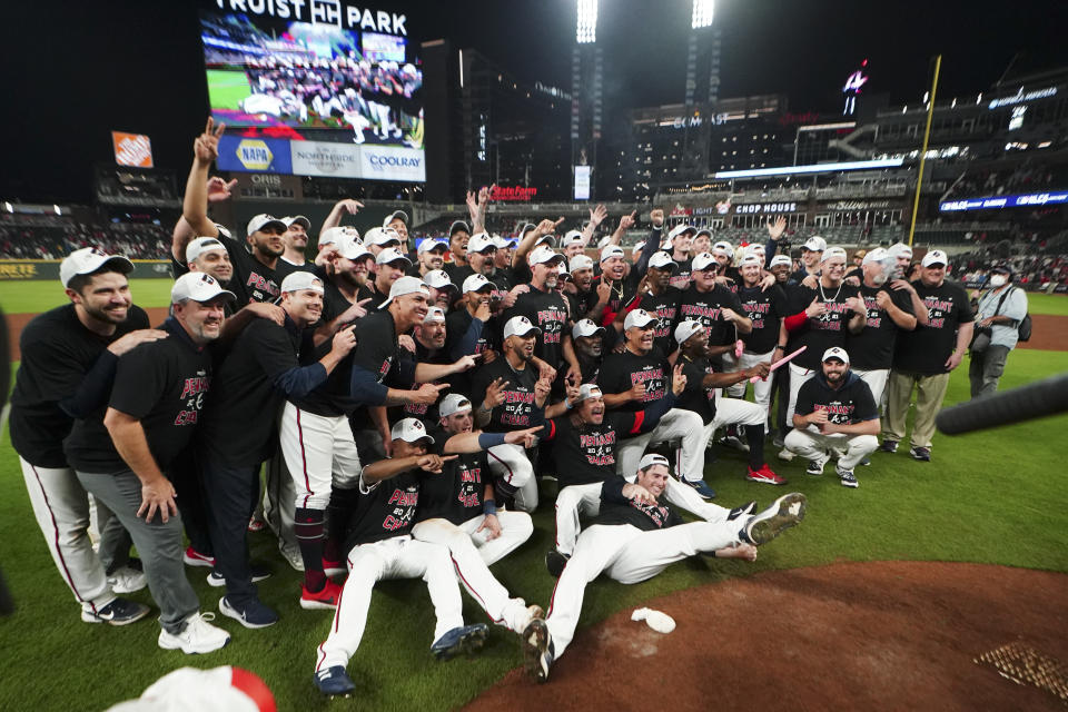 The Atlanta Braves pose fopr a photo after Game 4 of a baseball National League Division Series against the Milwaukee Brewers, Tuesday, Oct. 12, 2021, in Atlanta. The Atlanta Braves won 5-4 to advance to the NCLS. (AP Photo/John Bazemore)