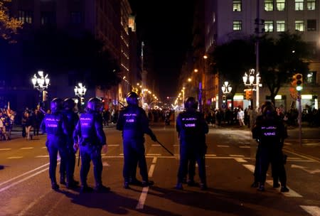 Riot police stand guard during a protest after a verdict in a trial over a banned independence referendum, in Barcelona