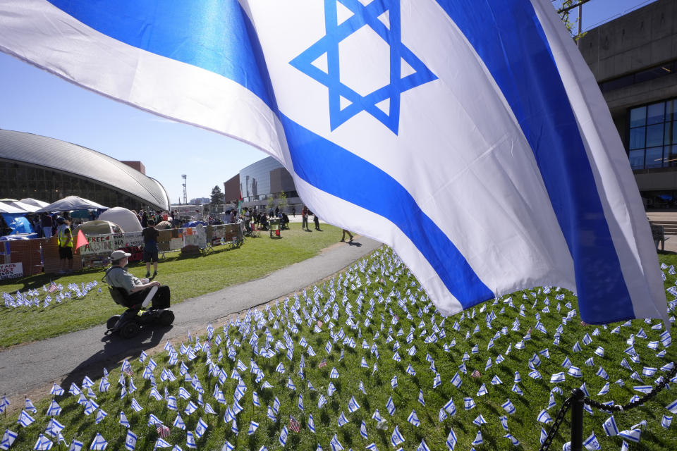 An Israeli flag, top, flies Tuesday, May 7, 2024, near an encampment of tents, behind left, on the Massachusetts Institute of Technology campus, in Cambridge, Mass., set up by MIT students and supporters to protest what they said was the school's failure to call for an immediate ceasefire in Gaza and to cut ties to Israel's military. The Israeli flags were put in place following the establishment of the tent encampment that was built to demand that MIT condemn Israel's war effort in Gaza. (AP Photo/Steven Senne)