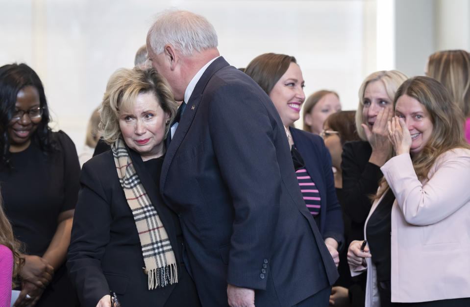 Minnesota Gov. Tim Walz, center, hugs first lady Gwen Walz as tears run down her face after the governor signed a bill that adds a "fundamental right" to abortion access into state law in St. Paul, Minn., on Tuesday, Jan. 31, 2023. On the right are Rep. Carlie Kotyza-Witthuhn, DFL-Eden Prairie, and state Sen. Jennifer McEwen, DFL-Duluth, who also wiped away tears. Walz's signature makes Minnesota the sixteenth state to spell out a right to abortion access in its law books or constitution, and the first state Legislature to take such action since Roe v. Wade was overturned in June 2022. (Glen Stubbe/Star Tribune via AP)