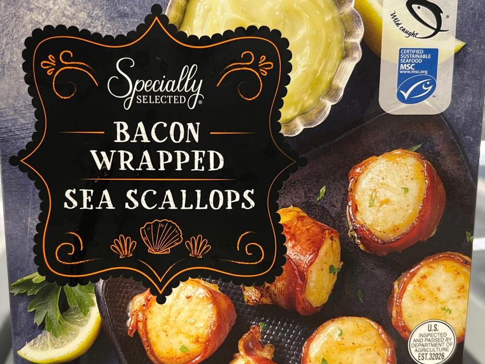 A box of Specially Selected bacon-wrapped scallops with a black label and pictures of scallops on the box