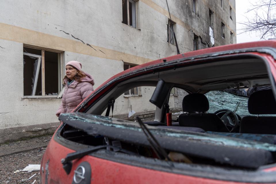 A woman walks past a car damaged as a result of a drone attack in Odesa on Dec. 14, 2023. Ukraine said on Dec. 14, 2023, that its air-defense systems had downed dozens of Iranian-designed drones launched by Russian forces targeting the southern city of Odesa in Moscow's latest overnight barrage.