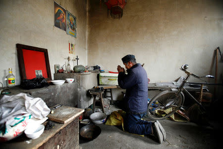 Chinese Catholic Ren Guilong prays at his home in a village on the outskirts of Taiyuan, Shanxi province, December 20, 2007. REUTERS/Reinhard Krause/File Photo