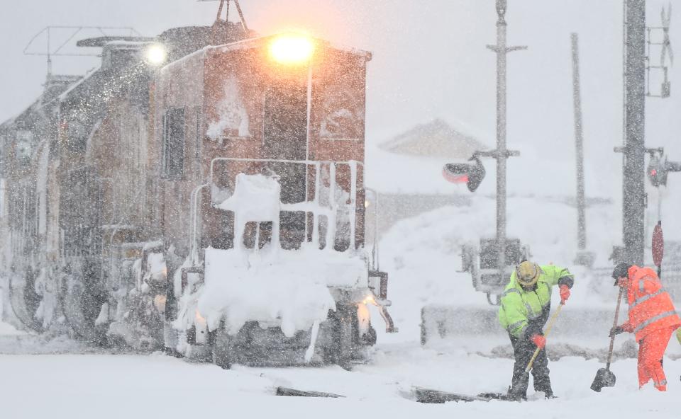 Workers clear train tracks as snow falls north of Lake Tahoe in the Sierra Nevada mountains during a powerful winter storm on March 01, 2024 in Truckee, California.