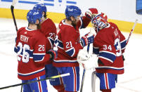 Montreal Canadiens' Jeff Petry, Eric Staal and Jake Allen, right, celebrate the team's victory over the Calgary Flames in an NHL hockey game Friday, April 16, 2021, in Montreal. (Paul Chiasson/The Canadian Press via AP)
