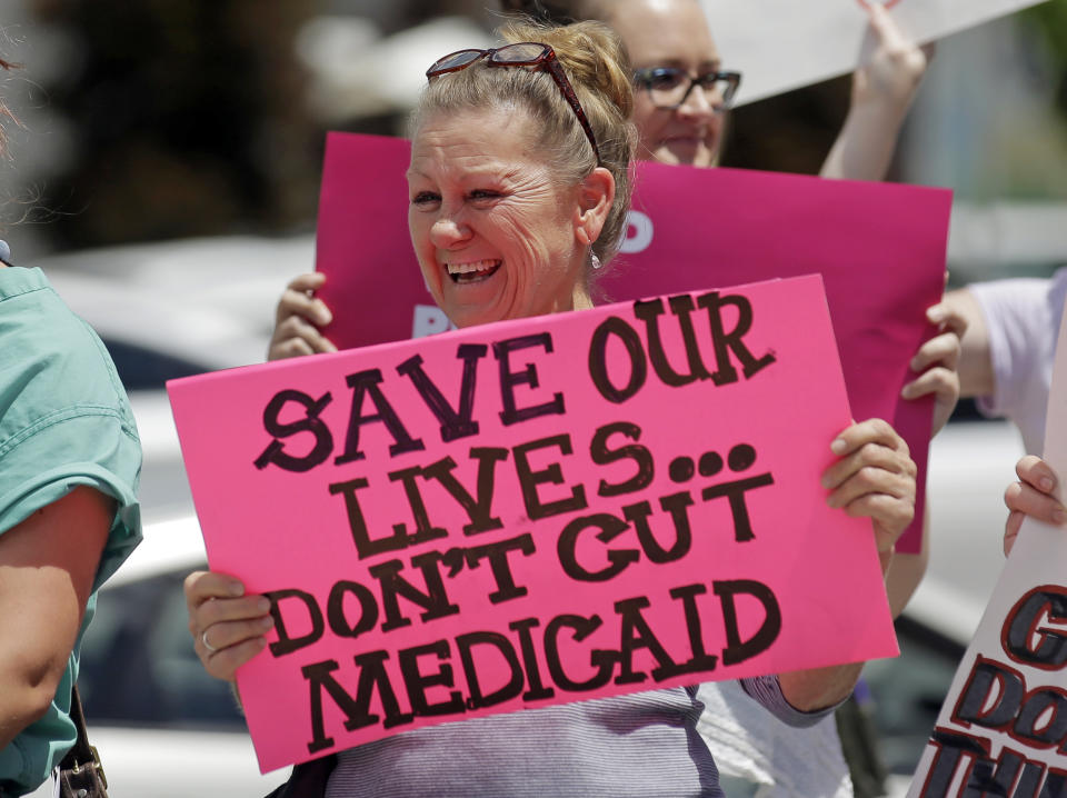 FILE - In this June 27, 2017 file photo, protesters block a street during a demonstration against the Republican bill in the U.S. Senate to replace former President Barack Obama's health care law, in Salt Lake City. The Trump administration will allow Medicaid expansion with a work requirement in Utah, a decision that came Monday, Dec. 23, 2019, despite courts taking a dim view of the requirement in other states. (AP Photo/Rick Bowmer, File)