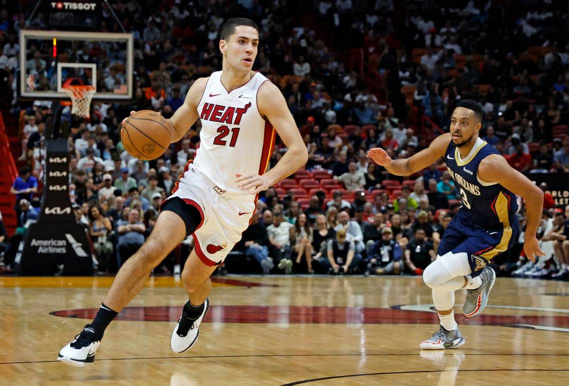 Miami Heat forward Cole Swider (21) drives the ball as New Orleans Pelicans guard CJ McCollum (3) gives chase in the fourth quarter at Kaseya Center in Miami on March 22, 2024.