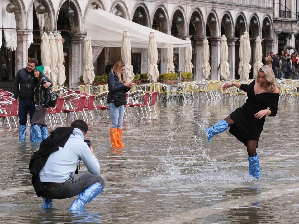 People have fun in a flooded St. Mark's Square during seasonally high water in Venice, Italy, November 7, 2021.