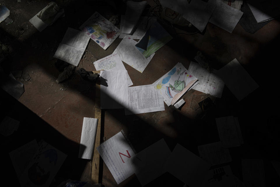 School papers and drawings are scattered inside a school which had been used by Russian forces as a headquarters and where civilians said they were held and tortured, in Izium, Ukraine, Wednesday, Sept. 21, 2022. (AP Photo/Evgeniy Maloletka)