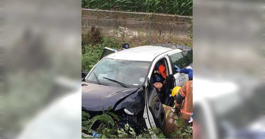 警車在押解犯人時，不慎發生自撞意外，衝撞護欄後翻落邊坡至農地。（圖／翻攝畫面）