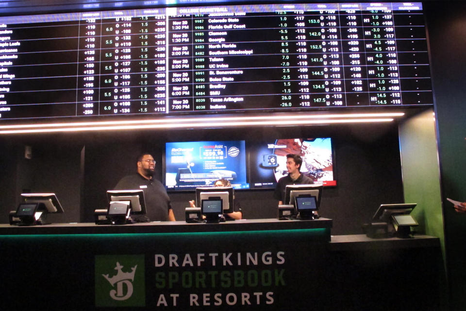 FILE - Employees work at the DraftKings sportsbook at Resorts Casino in Atlantic City N.J., in Nov. 20, 2018. In an action made public on Wednesday, March 2, 2022, New Jersey gambling regulators fined DraftKings $150,000 for allowing a Florida man to make online bets from his home by using a friend in New Jersey to place them for him, in violation of New Jersey's ban on proxy betting. (AP Photo/Wayne Parry, File)