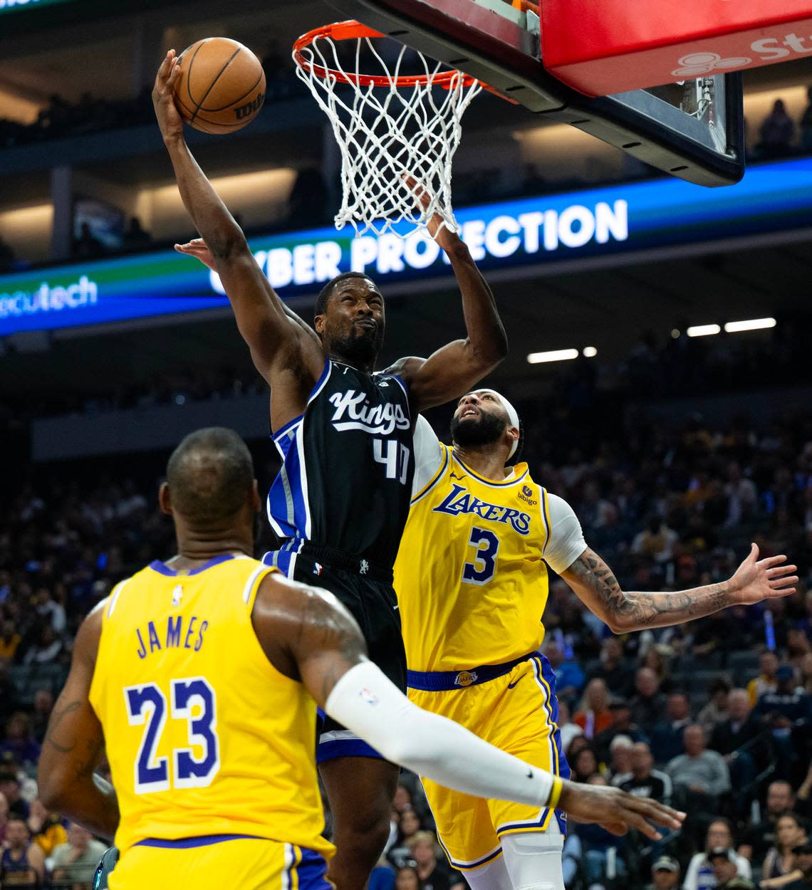 Sacramento Kings forward Harrison Barnes (40) drives to the basket between Los Angeles Lakers forwards LeBron James (23) and Anthony Davis (3) during a game at Golden 1 Center on Wednesday.