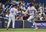 New York Mets' Mark Canha (19) shakes hands with third base coach Joey Cora after hitting a home run during the seventh inning of a baseball game against the Miami Marlins, Saturday, April 1, 2023, in Miami. (AP Photo/Michael Laughlin)