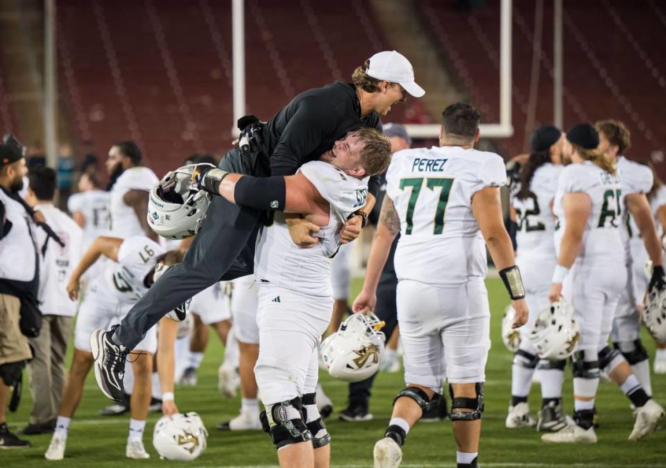 Sacramento State Hornets offensive lineman Jackson Slater (76) lifts up strength coach Nathan Morris as the team celebrates their 30-23 win over the Stanford Cardinal on Saturday.