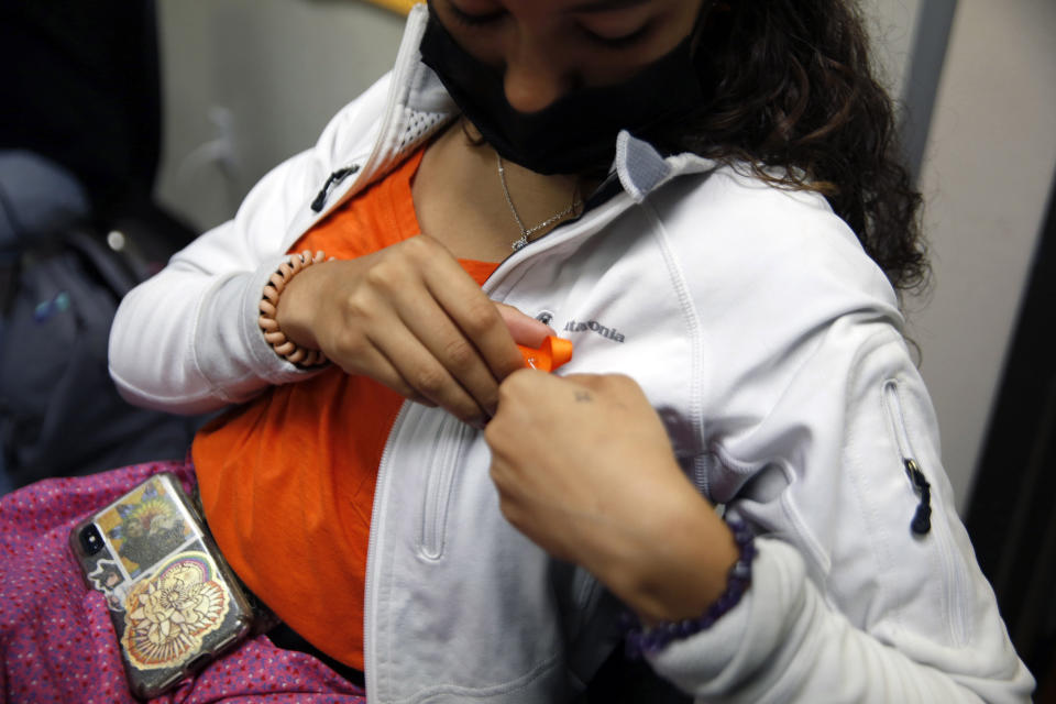 Esperanza Rama, a sophomore at Red Cloud Indian School, pins an orange ribbon to her shirt on Sept. 20, 2021, in Pine Ridge, S.D. Students and teachers wore orange in solidarity with Indigenous children of past generations who suffered cultural loss, family separation and sometimes abuse and neglect while compelled to attend hundreds of residential schools that once dotted the map across the United States and Canada from the late 19th to the mid-20th centuries. (AP Photo/Emily Leshner)