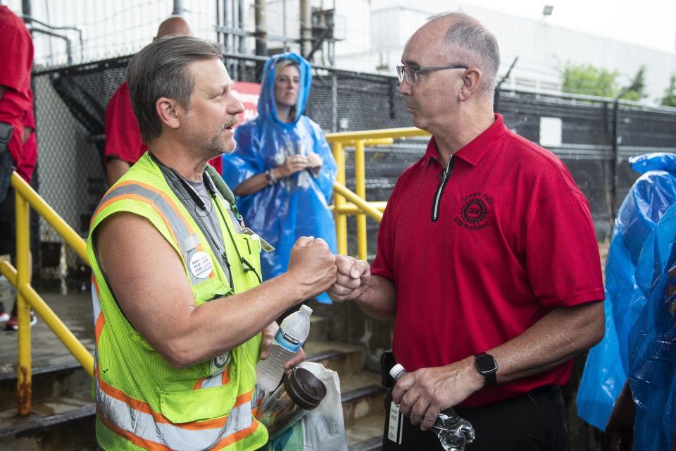 UAW president Shawn Fain fist-bumps with Ford worker Dan Louzon outside of Ford's Michigan Assembly Plant in Wayne on Wednesday, July 12, 2023.