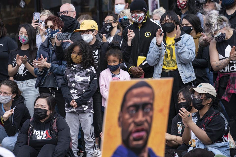 Demonstrators gather for a solidarity rally lead by community organizers in the Black and Asian communities in memory of George Floyd and Daunte Wright outside Cup Foods, Sunday, April 18, 2021, in Minneapolis. (AP Photo/John Minchillo)