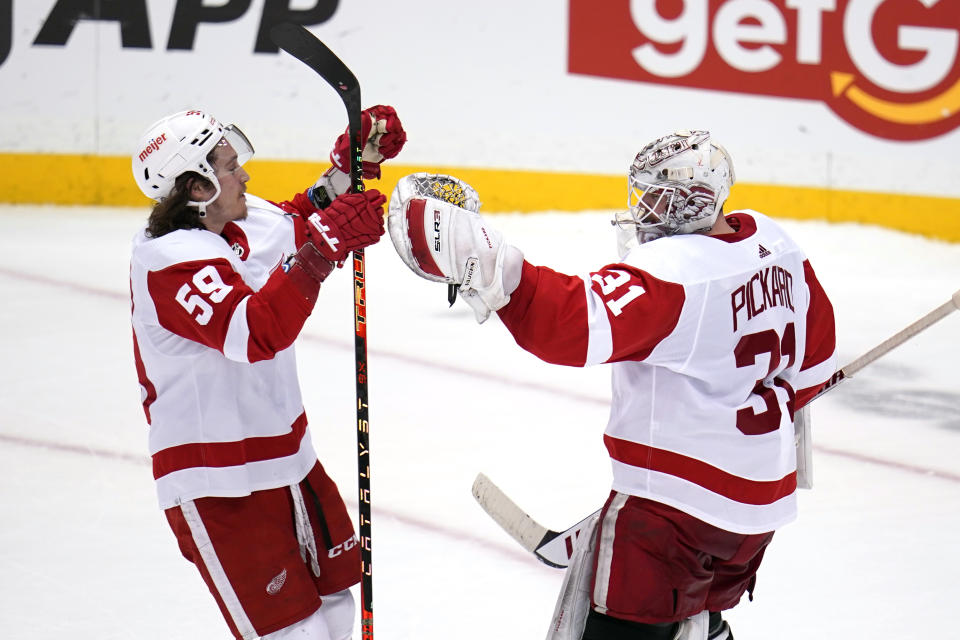 Detroit Red Wings goaltender Calvin Pickard (31) celebrates with Tyler Bertuzzi (59) after a shootout win over the Pittsburgh Penguins in an NHL hockey game in Pittsburgh, Friday, Jan. 28, 2022. (AP Photo/Gene J. Puskar)