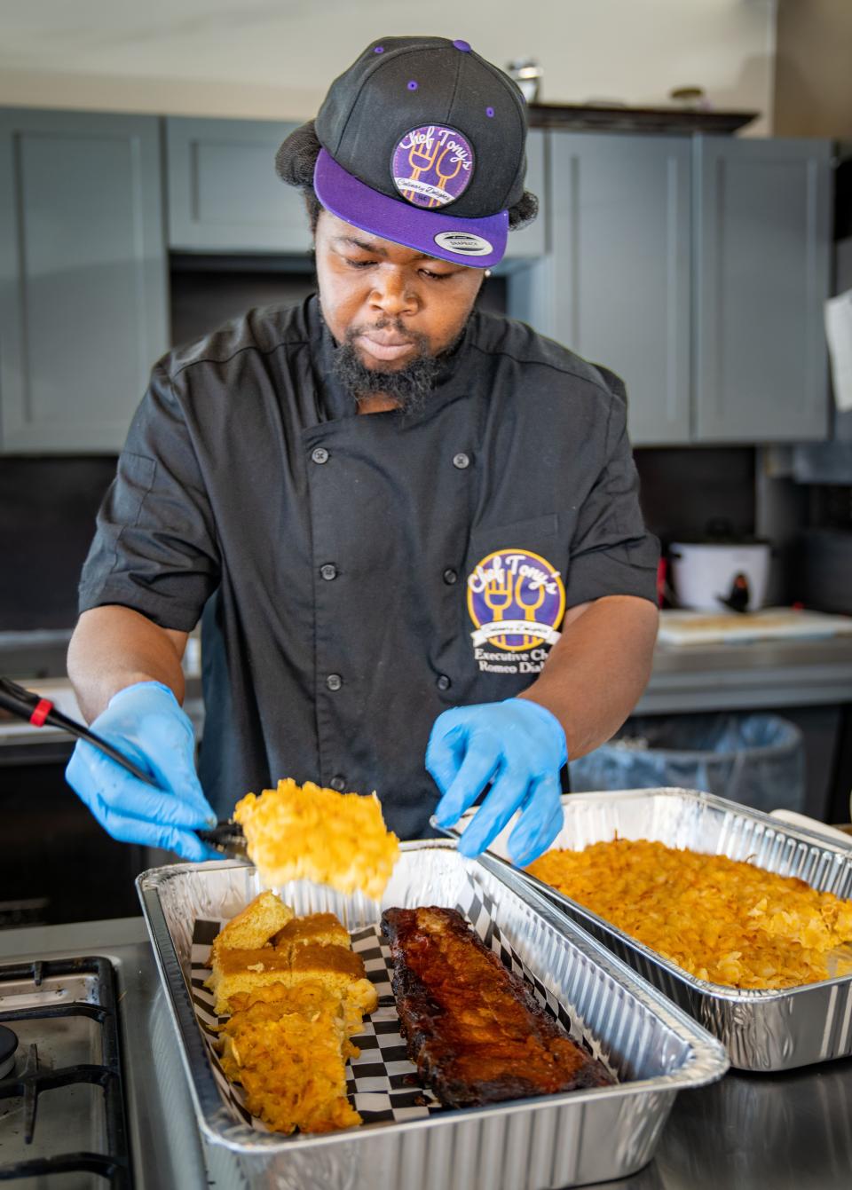 Romeo Diahn makes a platter of pork ribs, corn bread, and macaroni and cheese at Kitchen Spaces in the Drake neighborhood, where he is hosting his Thursday-only restaurant, Chef Tony's Culinary Delights.