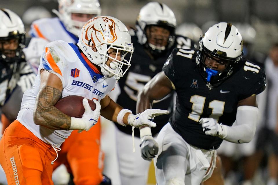 Boise State running back Cyrus Habibi-Likio, left, looks to run past Central Florida linebacker Jeremiah Jean-Baptiste (11) during the first half of an NCAA college football game Thursday, Sept. 2, 2021, in Orlando, Fla. (AP Photo/John Raoux)