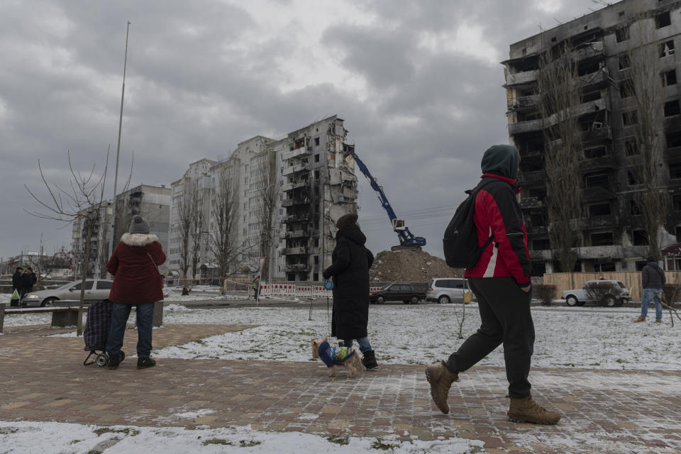 Residentes observan mientras un edificio atacado es desmantelado en Borodyanka, en la región de Kiev, Ucrania, el martes 13 de diciembre de 2022. (AP Foto/Andrew Kravchenko)