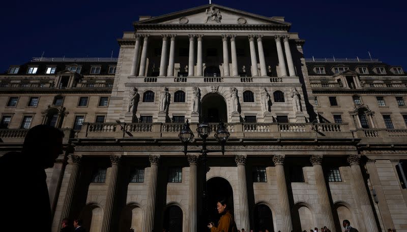 FILE PHOTO: People walk outside the Bank of England in London