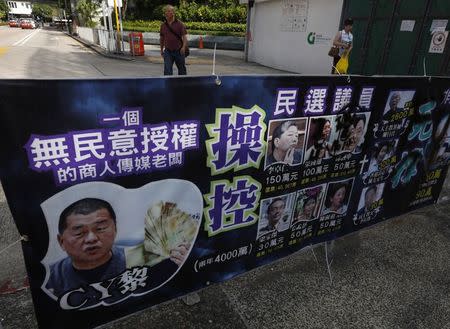 A poster mocking Jimmy Lai Chee-ying, chairman of Next Media, offering money to pro-democracy lawmakers, is displayed at Hong Kong's financial Central district August 29, 2014. REUTERS/Bobby Yip