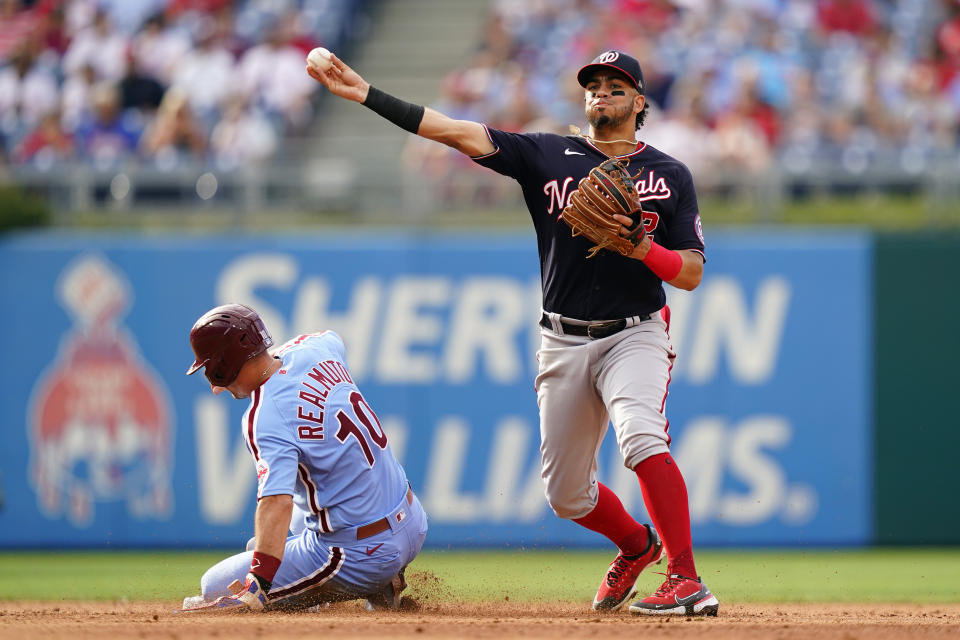 Washington Nationals shortstop Luis Garcia, right, throws to first after forcing out Philadelphia Phillies' J.T. Realmuto at second on a fielder's choice hit into by Didi Gregorius during the fifth inning of a baseball game, Thursday, July 7, 2022, in Philadelphia. (AP Photo/Matt Slocum)