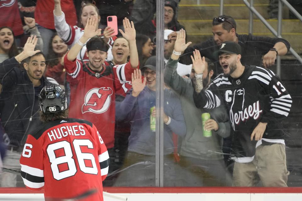 New Jersey Devils center Jack Hughes (86) celebrates with the fans after scoring against the Columbus Blue Jackets during the second period of an NHL hockey game Thursday, April 6, 2023, in Newark, N.J. (AP Photo/Mary Altaffer)